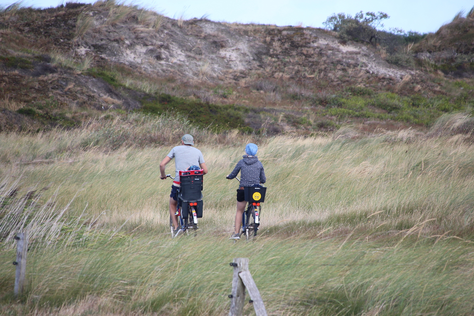 A couple biking in the dunes of Langeoog island (Germany)