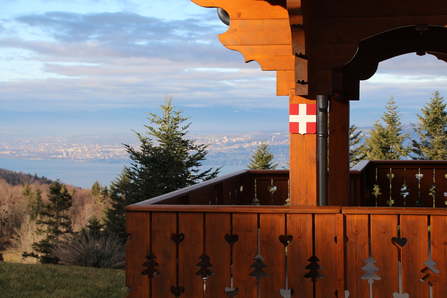 Sight over lake of Geneva with a chalet in the foreground and the flag of Savoy